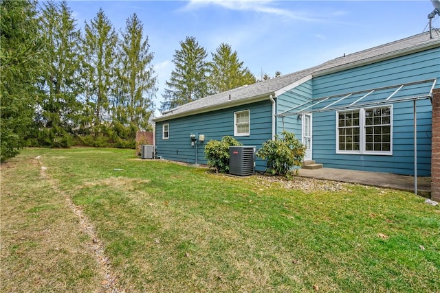 exterior space featuring central AC unit, entry steps, and a lawn