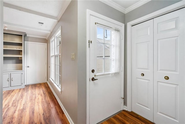 foyer entrance with baseboards, wood finished floors, and crown molding