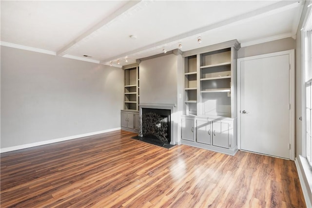 unfurnished living room featuring a fireplace with flush hearth, wood finished floors, baseboards, and ornamental molding