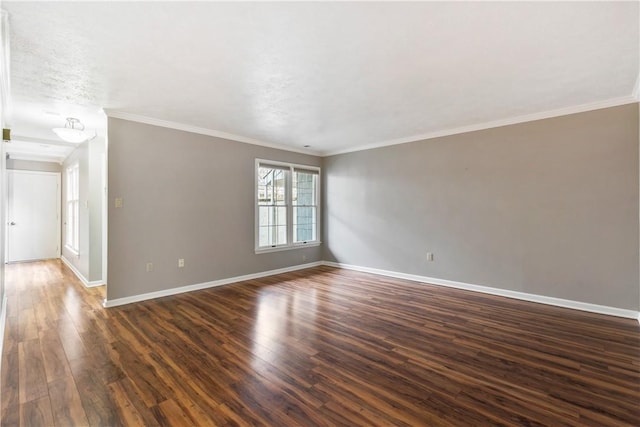 empty room with dark wood-type flooring, baseboards, and ornamental molding