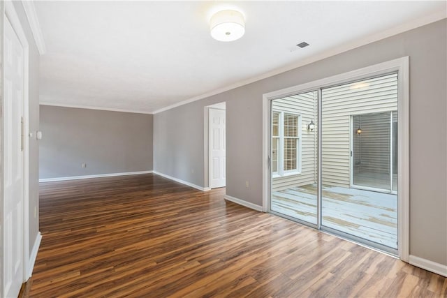 unfurnished room featuring visible vents, ornamental molding, baseboards, and wood finished floors