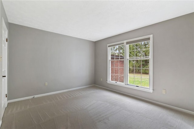 carpeted empty room featuring baseboards