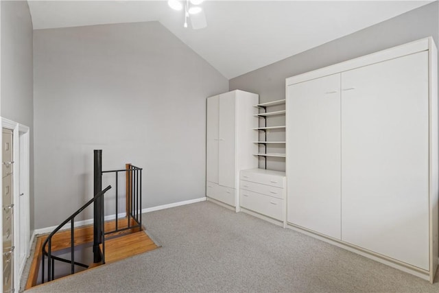 interior space featuring baseboards, light carpet, high vaulted ceiling, and a ceiling fan