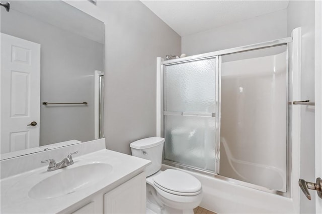 bathroom with bath / shower combo with glass door, toilet, and vanity