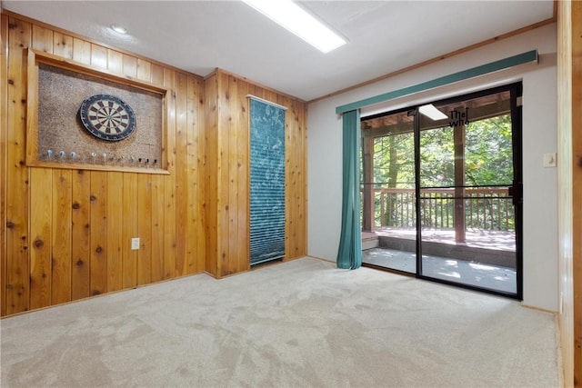 unfurnished room featuring carpet, crown molding, and wooden walls