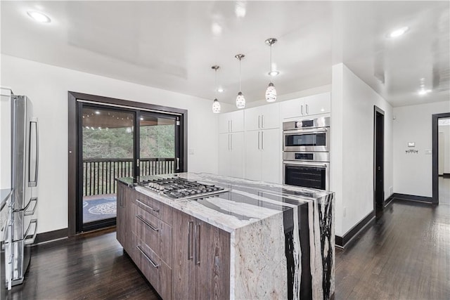 kitchen with a center island, dark wood-style flooring, stainless steel appliances, white cabinetry, and modern cabinets