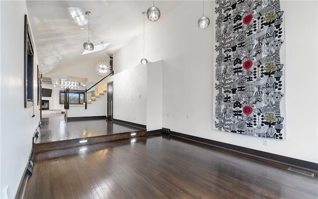 interior space with visible vents, wood finished floors, high vaulted ceiling, baseboards, and stairs