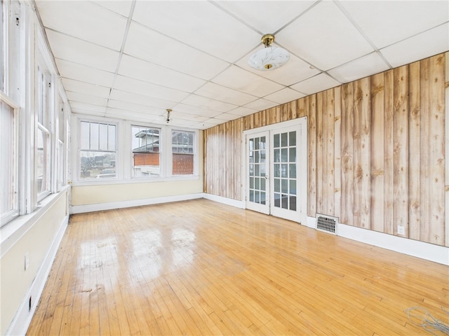 unfurnished sunroom featuring a paneled ceiling, french doors, and visible vents