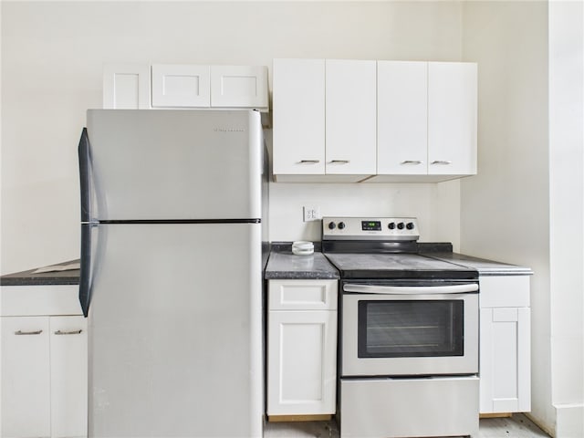 kitchen featuring dark countertops, white cabinetry, and stainless steel appliances