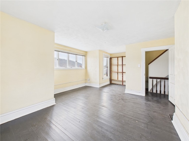 empty room with dark wood-style floors and baseboards