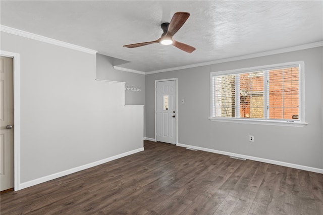 empty room featuring crown molding, dark wood finished floors, ceiling fan, a textured ceiling, and baseboards