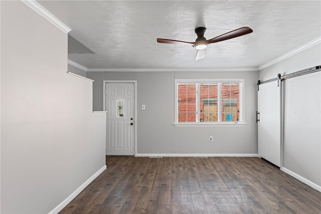 entrance foyer with crown molding, a barn door, ceiling fan, baseboards, and hardwood / wood-style flooring