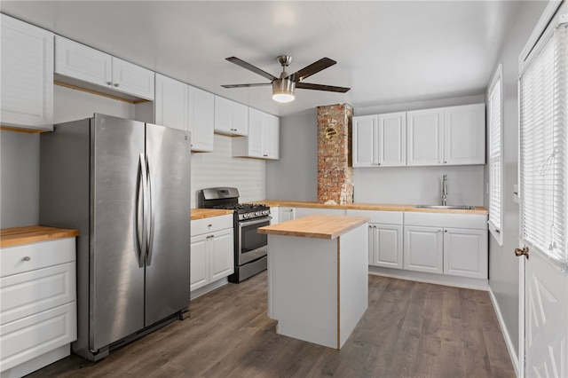 kitchen with white cabinetry, butcher block counters, appliances with stainless steel finishes, and a sink