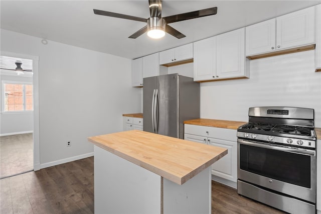 kitchen with dark wood-type flooring, wood counters, white cabinetry, a ceiling fan, and appliances with stainless steel finishes