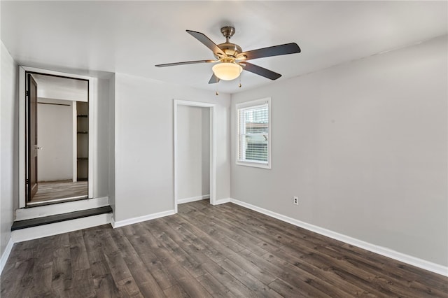 unfurnished bedroom with dark wood-style flooring, ceiling fan, and baseboards