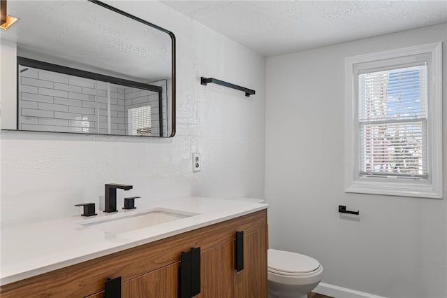 full bathroom with a textured ceiling, toilet, vanity, baseboards, and an enclosed shower