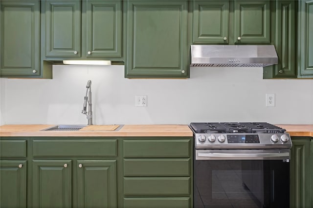 kitchen featuring butcher block counters, a sink, green cabinets, wall chimney range hood, and stainless steel range with gas stovetop