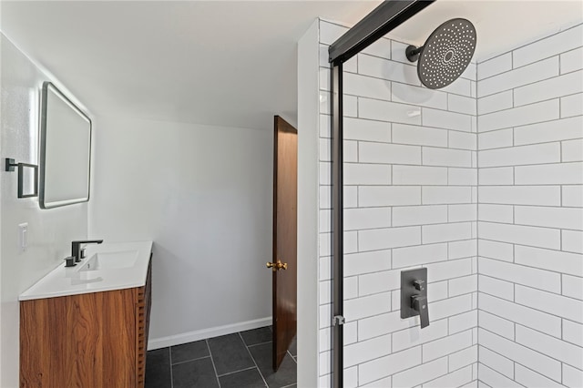 full bathroom with tile patterned flooring, baseboards, a tile shower, and vanity