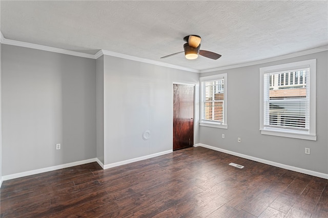 empty room featuring wood-type flooring, visible vents, baseboards, and ornamental molding