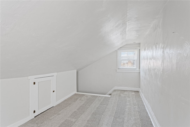 bonus room with carpet, baseboards, vaulted ceiling, and a textured ceiling