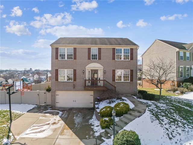 view of front of home with a garage, brick siding, fence, driveway, and a gate