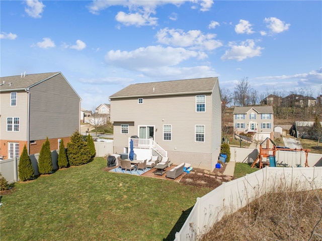 rear view of property featuring a patio, a lawn, a fenced backyard, and a residential view