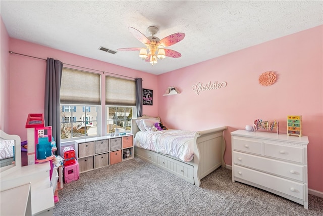 bedroom featuring visible vents, ceiling fan, a textured ceiling, and carpet flooring