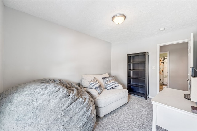 bedroom with a textured ceiling and light colored carpet