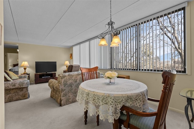 dining room featuring an inviting chandelier, carpet, and a textured ceiling