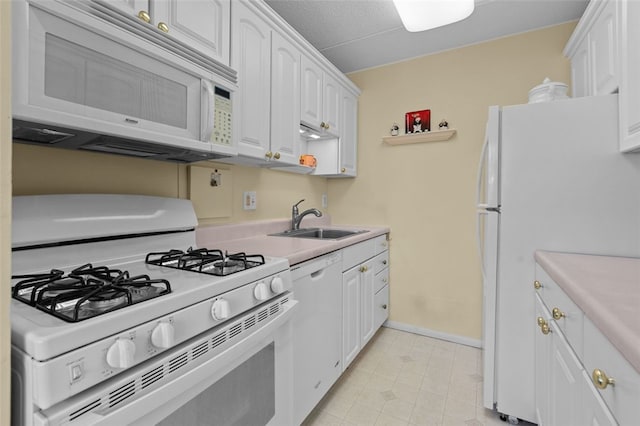 kitchen with light countertops, white appliances, a sink, and white cabinetry