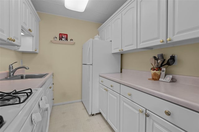 kitchen featuring light countertops, white appliances, white cabinets, and a sink