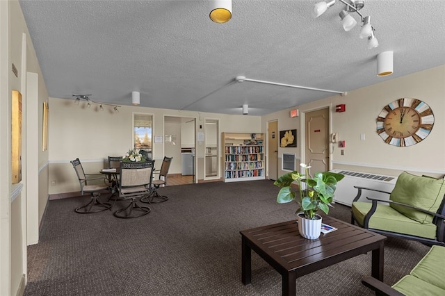 interior space featuring baseboards, a textured ceiling, and track lighting