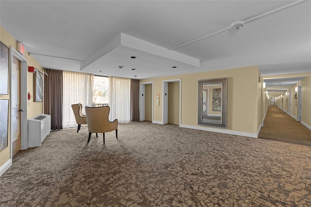 sitting room featuring baseboards, carpet flooring, and elevator