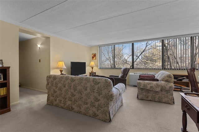 living area featuring light carpet, a textured ceiling, plenty of natural light, and baseboards