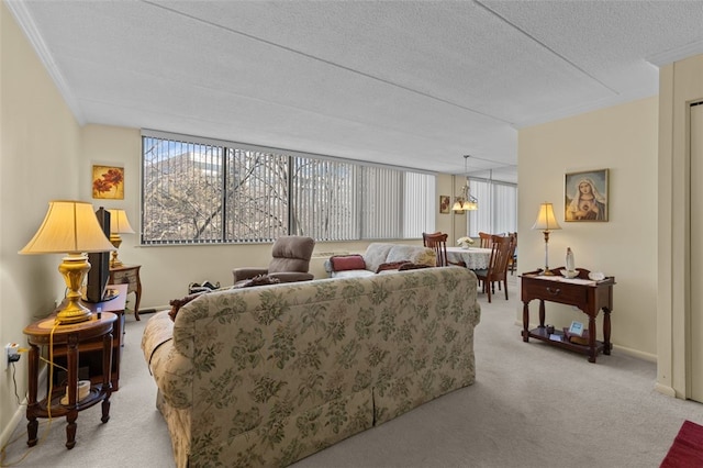 living area featuring light colored carpet, a textured ceiling, and baseboards