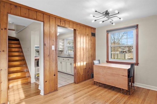 living area with ornamental molding, stairway, plenty of natural light, and light wood-style flooring