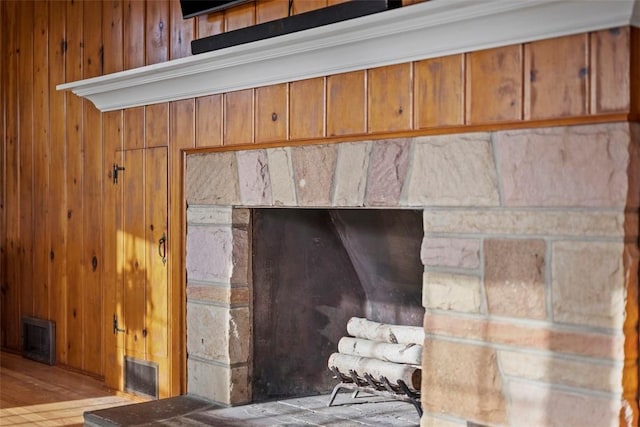 details featuring wood walls, wood finished floors, and visible vents