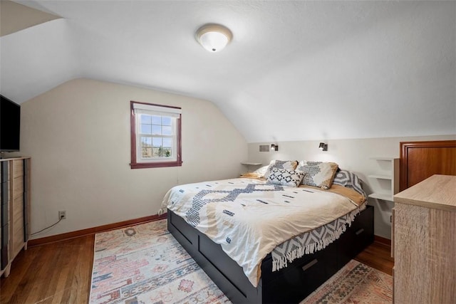 bedroom featuring vaulted ceiling, baseboards, and wood finished floors