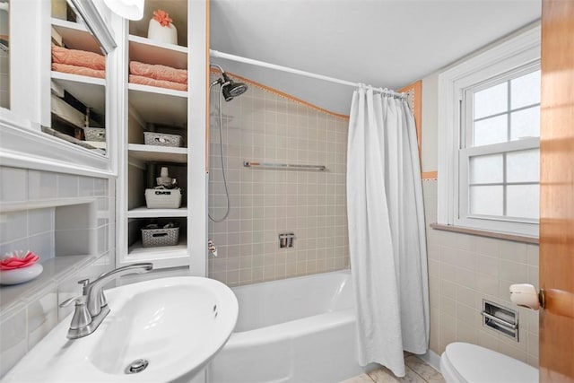 full bath with toilet, a sink, tile walls, built in features, and tile patterned floors