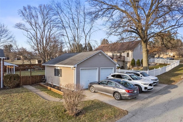 exterior space featuring a garage, roof with shingles, an outbuilding, and fence