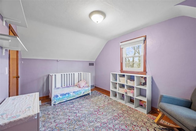 bedroom with lofted ceiling, visible vents, and baseboards