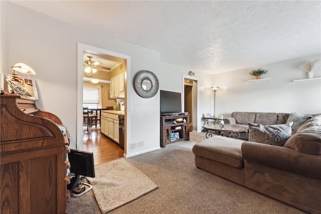 carpeted living area featuring visible vents and a textured ceiling