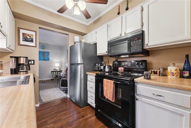 kitchen with dark wood-type flooring, a sink, white cabinetry, black appliances, and crown molding