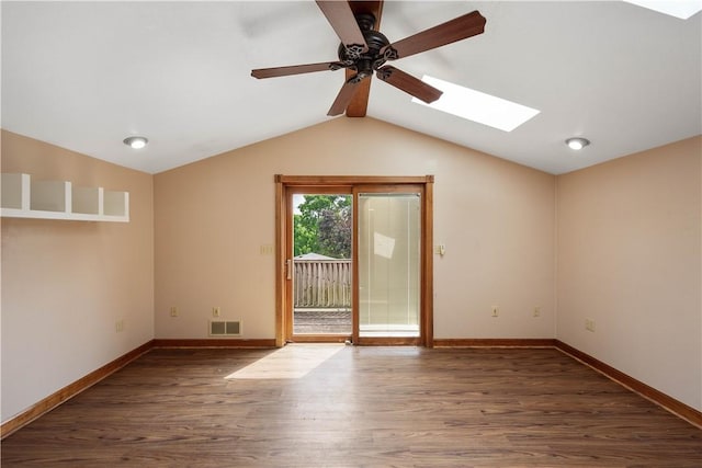 empty room featuring wood finished floors, a ceiling fan, visible vents, baseboards, and lofted ceiling with skylight