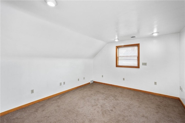 bonus room featuring carpet floors, baseboards, visible vents, and vaulted ceiling