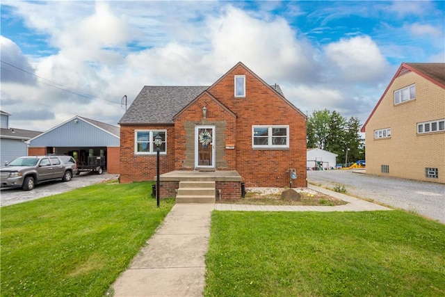 bungalow with a front lawn, a shingled roof, and brick siding