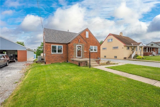 bungalow-style home featuring roof with shingles, a front yard, cooling unit, and brick siding