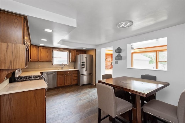 kitchen featuring recessed lighting, stainless steel appliances, light countertops, decorative backsplash, and brown cabinetry