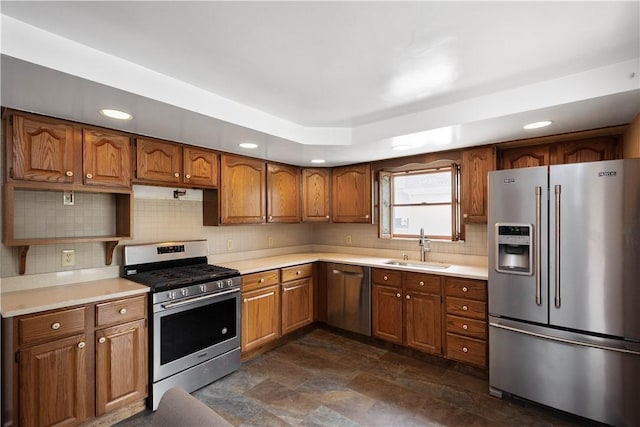 kitchen with appliances with stainless steel finishes, a sink, and brown cabinets