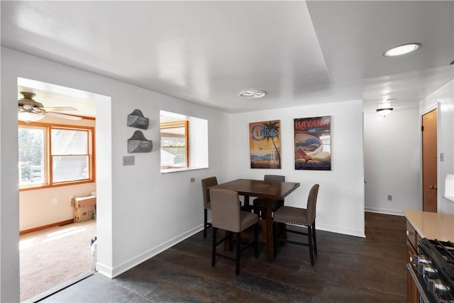 dining room with ceiling fan and baseboards